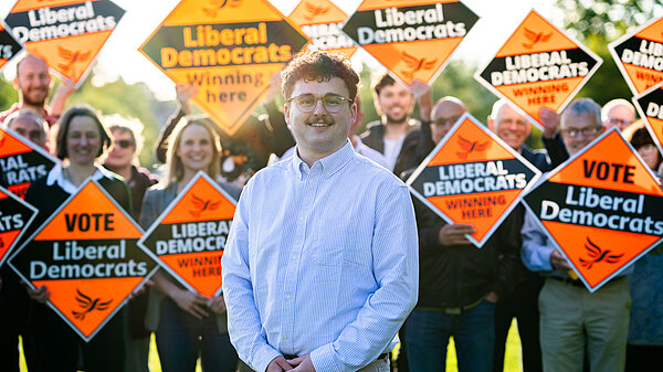 Sam in front of a crowd of happy Lib Dems